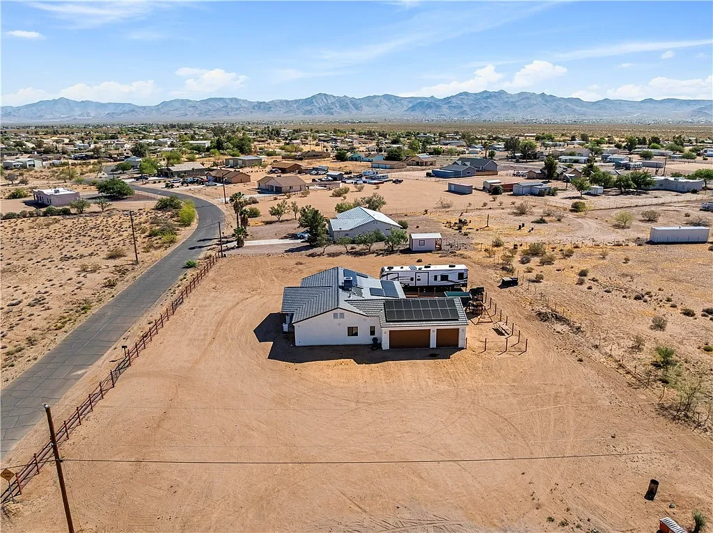 Aerial view of the home, solar panels, garage, RV area and surrounding desert