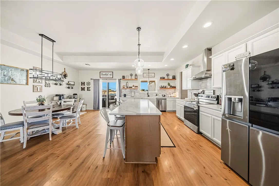 Kitchen island beside the dining area, with stainless appliances and doors to the patio