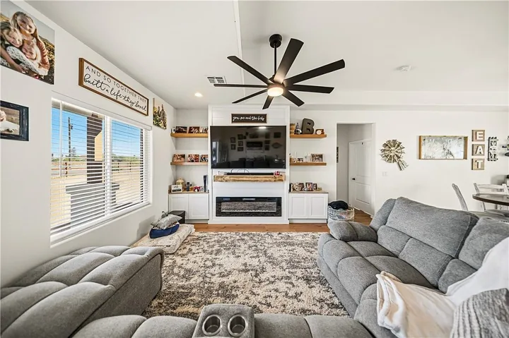 Living room with a sectional, entertainment wall and electric fireplace