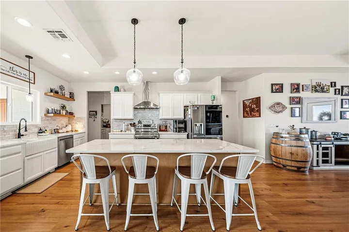 Kitchen with a large island, pendant lights and white cabinets